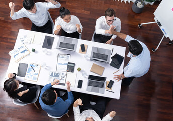 Top view diverse office employee worker high five after making agreement on strategic business marketing planning. Teamwork and positive attitude create productive and supportive workplace. Prudent