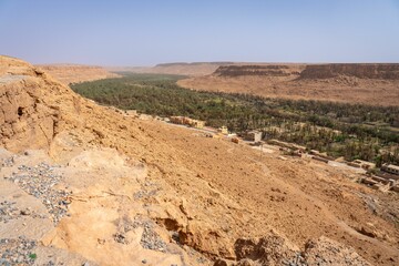 Desert valley with village and green trees