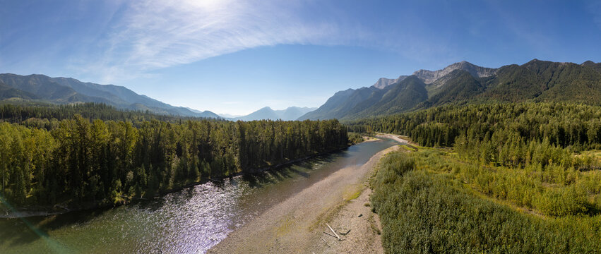 Scenic View of Lush Forest and River in Fernie, BC, Canada with Majestic Mountain Backdrop