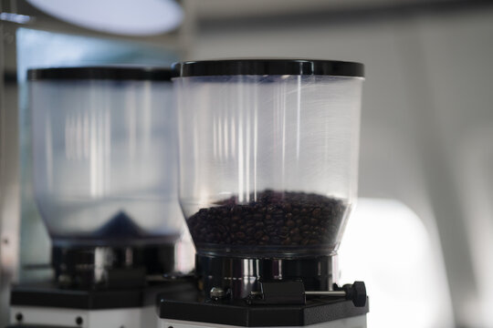 Coffee Bean Hopper: Close-up of a coffee bean hopper filled with dark roasted beans, ready to be ground for a delicious cup of coffee. The transparent container showcases the beans, creating a visual 