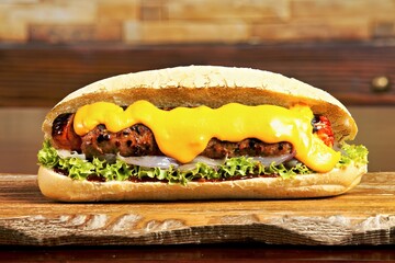 A delicious sandwich with grilled meat, cheese, and fresh vegetables in a bun.