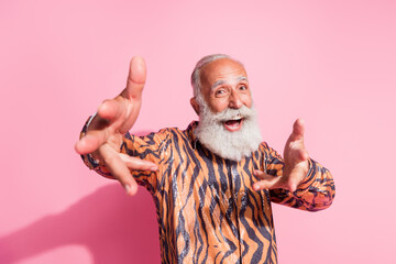 Photo of cheerful optimistic funny pensioner man wearing stylish print clothes looking camera isolated on pink color background