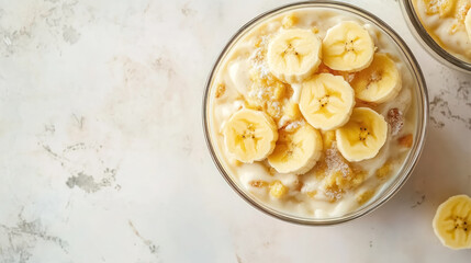 creamy banana pudding topped with fresh slices and sugar in glass bowl
