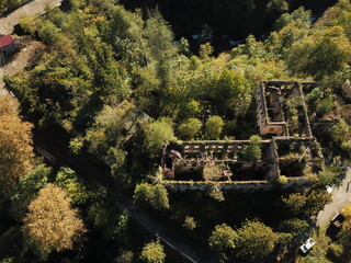 Aerial photos. A shot above an abandoned house in the mountains of Abkhazia in Akarmara. Stone walls and windows without glass, the wall is destroyed, and the area around
