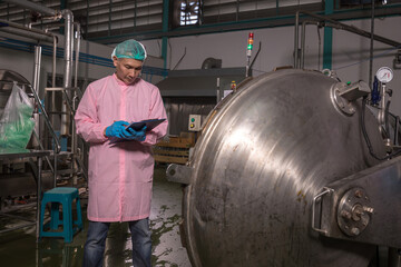 Worker Checking quality or checking stock of glass bottle in beverage factory. Worker QC working in a drink water factory