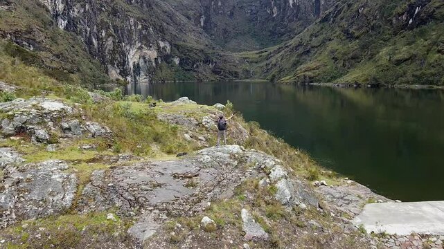 Hombre turista parado al lado de una laguna en las monta&ntilde;as.el turismo y el concepto de viaje.modo de vida saludable	