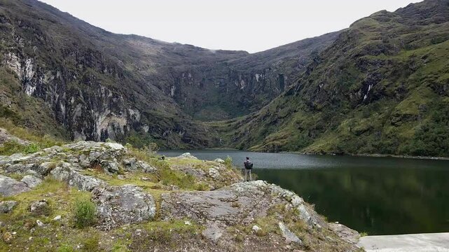 Hombre turista parado al lado de una laguna en las monta&ntilde;as.el turismo y el concepto de viaje.modo de vida saludable	