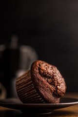 Sweet chocolate muffin cakes on plate on wooden table.