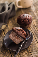 Sweet chocolate muffin cakes on plate on wooden table.