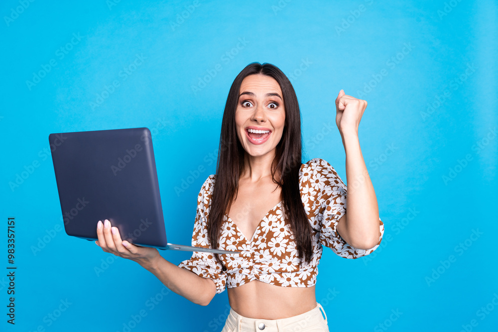 Sticker Photo of cheerful glad lovely woman wear trendy print clothes hold macbook yes fist isolated on blue color background