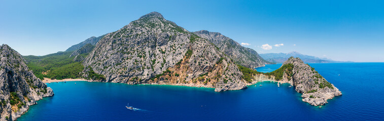Aerial View of the Mediterranean Coastline in Turkey with Majestic Rocky Cliffs, Tourist Boats, and Scenic Hiking Trails