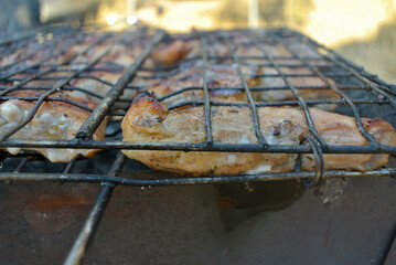 Fried meat on a grill on a grill with coals.