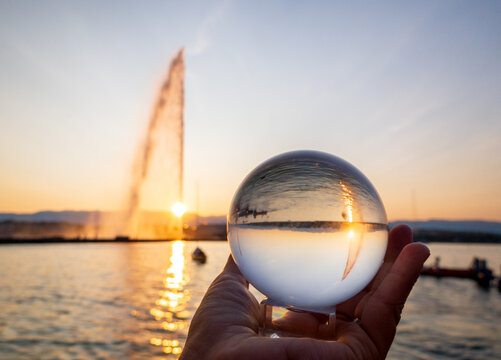 Crystal ball reflection of Geneva&rsquo;s Jet d'eau at sunset
