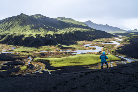 Lone traveler surveys rainy Icelandic highlands landscape - Powered by Adobe