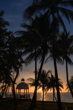 Sunset in Varadero with silhouetted palm trees and seaside gazebo
