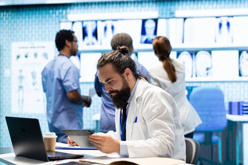 Fototapeta premium Professional medical team examine hospital records and treatment outcomes in a clinic to ensure quality insurance services. Physician specialist analyzing test results for expert solutions.