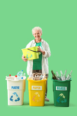 Senior woman with garbage bins on green background. Waste sorting concept