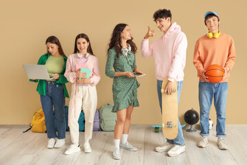 Group of teenage students near beige wall