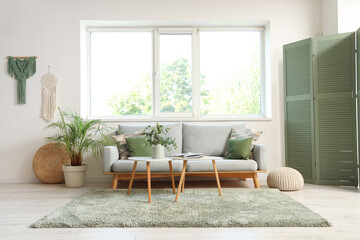 Interior of living room with sofa, tables and window