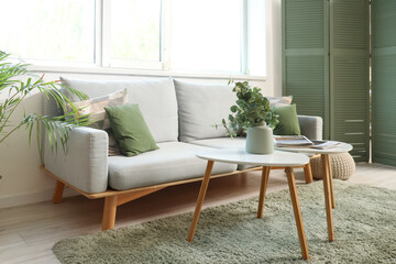 Interior of living room with sofa, tables and window