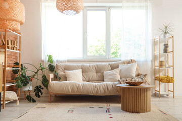 Interior of living room with sofa, shelf units and table
