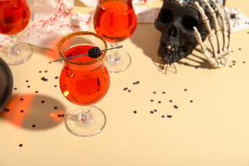 Glasses of tasty cocktails and decorations prepared for Halloween on color table