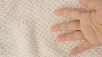 female Hand touching knitted wool cloth or warm fluffy sweater, Handcraft knitting woolen fabric surface, tactile properties, fabric testing - Powered by Adobe