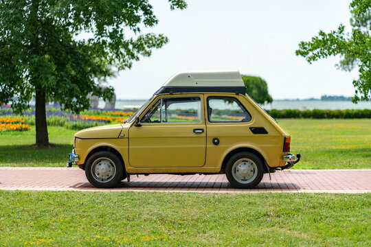 Side view Polish Fiat 126 (Polski Fiat 126p - "Maluch") in yellow color with roof-box (roof rack, high roof. Palic, Serbia, 02.07.2023