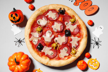 Composition with tasty Halloween pizza and different decorations on grey background