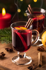 Mulled wine with orange and cinnamon in a glass glass. Hot wine with cinnamon. Warming winter drink with orange and cinnamon. Hot tea with orange and cinnamon.