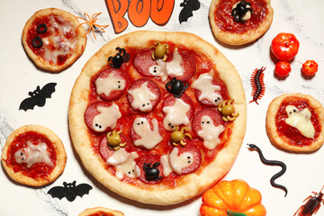 Composition with different pizzas and decorations on light background