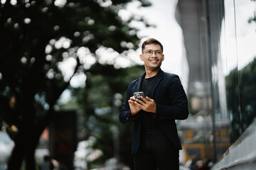 Urban Professional's Digital Stroll: A young Asian businessman in a sharp suit navigates the city, a confident smile illuminating his face as he checks his phone. 