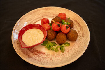 Falafel with tahini sauce on the plate with tomatoes