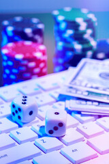 Game chips and cash on a dimly lit keyboard during an exciting gaming night at home