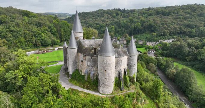 Castle of veves, The castle, on a grassy hill, has heavy walls, round towers and tall windows.