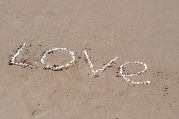 the inscription love on the wet sand of the sea beach in Turkey, lined with white shells, a love message, a declaration of love