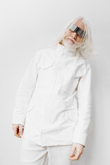 Fashion model with long white hair wearing futuristic glasses and a white jacket on a minimalist...