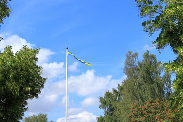 Swedish flag and green trees. V&auml;sterg&ouml;tland, Sweden, Europe.