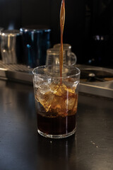 Cold Brew Coffee Being Poured Over Ice in a Café
