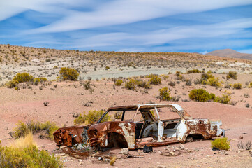 Abandoned car wreckage rusting in the desert