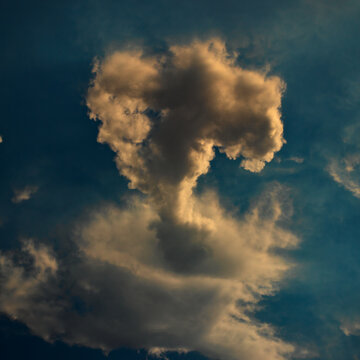 cloud shaped by the winds like a mushroom under a blue sky.
