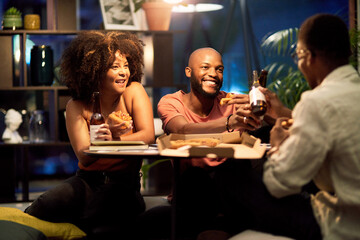 Happy friends, beer and business people cheers at office party to celebrate project launch success. Alcohol, drink and African group toast, eating pizza or food after deadline at night on Octoberfest