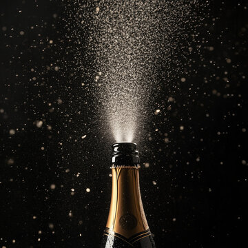 champagne bottle on black exploding in celebration
