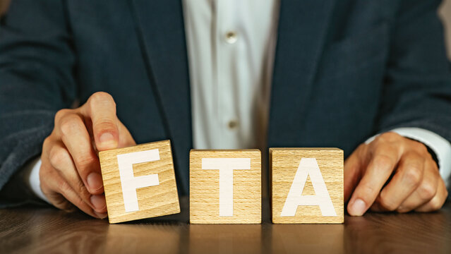 There is wood cube with the word FTA. It is an abbreviation for Free Trade Agreement as eye-catching image.