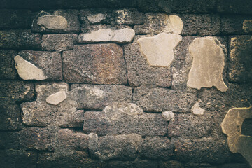 Surface of the Block brick wall is old, dirty and covered with black mold .