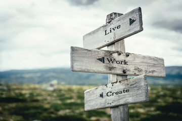 live work create text quote on wooden directional signpost outdoors in nature