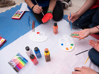 Children and adults make shapes and sculptures with play dough and draw pictures.