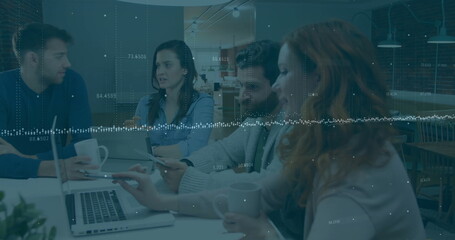 Fototapeta premium Financial data processing image over diverse business people working on laptops