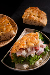 Food concept homemade focaccia, focaccia feta cheese and bacon on black background with copy space