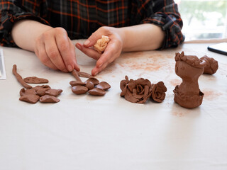 Children and adults make shapes and sculptures with play dough and draw pictures.